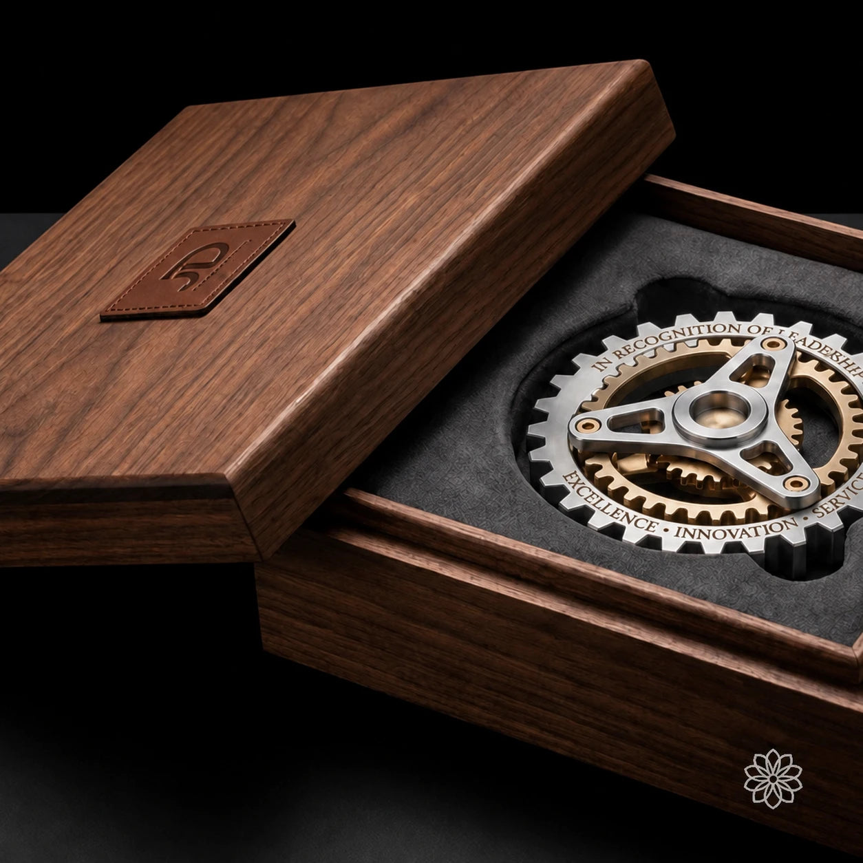 A sculptural metal recognition piece in a fitted walnut presentation case.