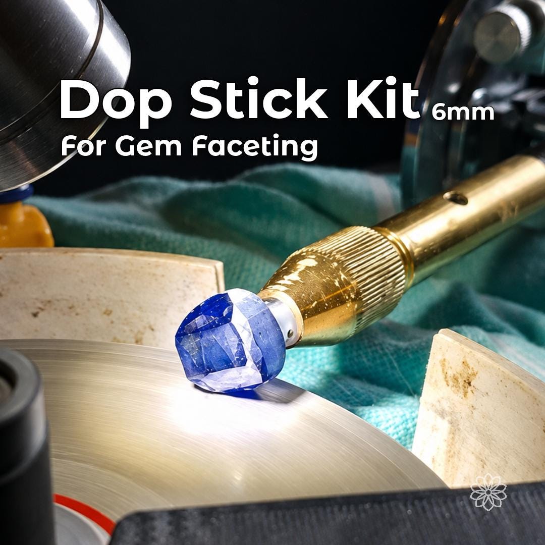 Blue faceted gemstone held in a brass quill above a rotating faceting lap.