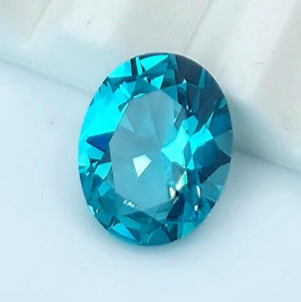 Oval-cut Paraiba sapphire gemstone with vivid blue color on white background – suitable for jewelry making or custom design work