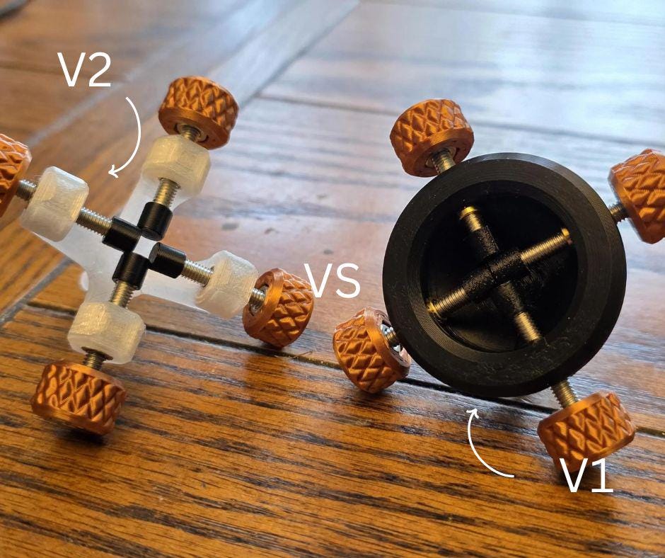 Side-by-side comparison of Gem Axis V2 and V1 alignment jigs on a wooden surface. V2 features white bushings and orange knobs with improved visibility and stone access, compared to the older black V1 design.