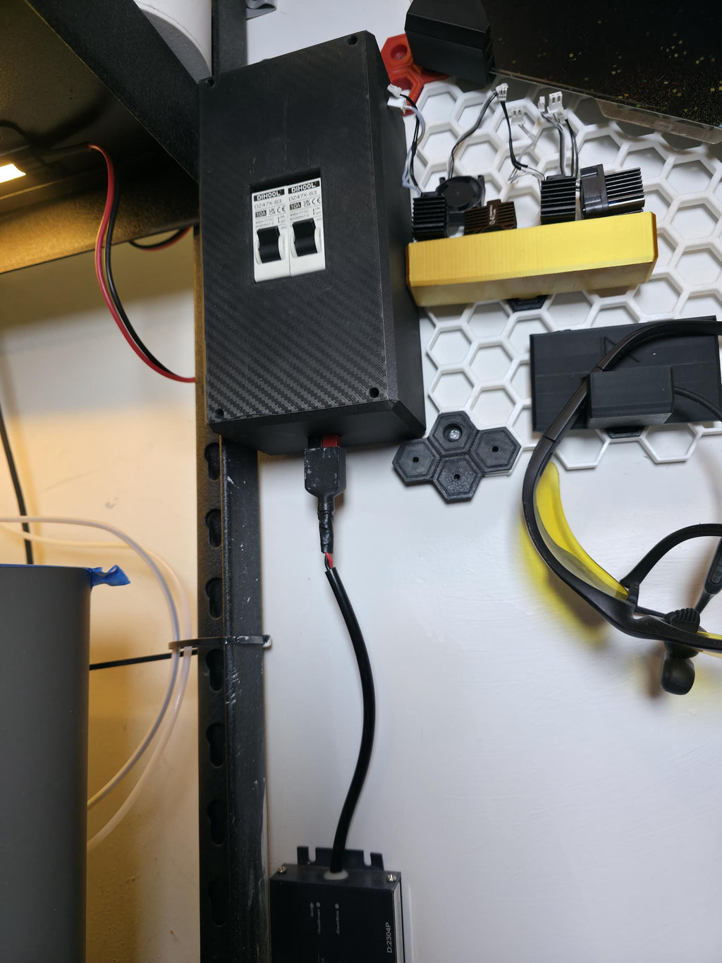 Aetherium DC breaker box integrated into a modular workstation with wiring leading to a power supply unit below. Compact design enables vertical mounting, ideal for hobby electronics, solar, or portable 12V systems.