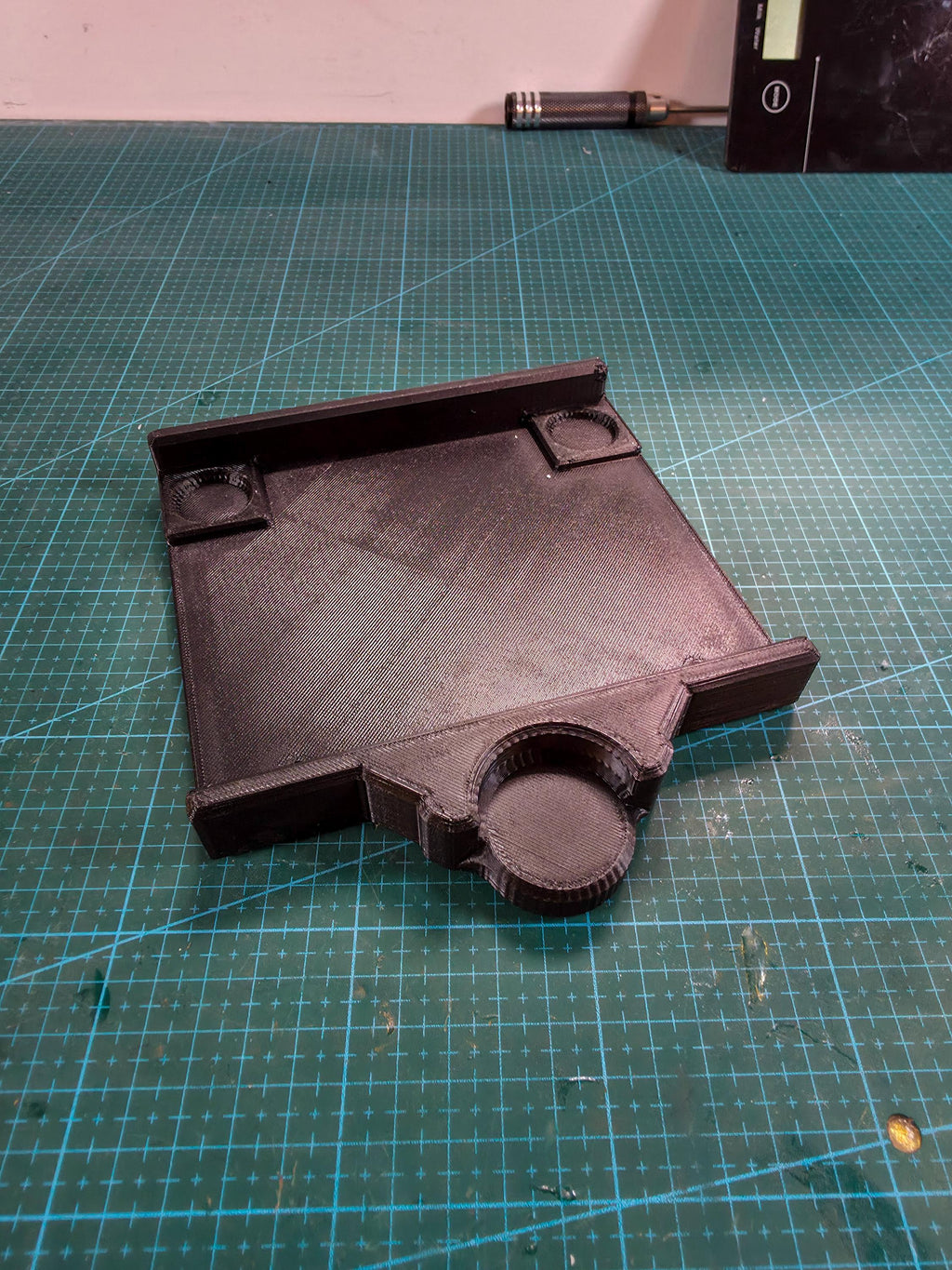 Macro shot of the adapter plate on the workbench, showing the recessed mount area and alignment ridge designed for universal bench lathe motors.