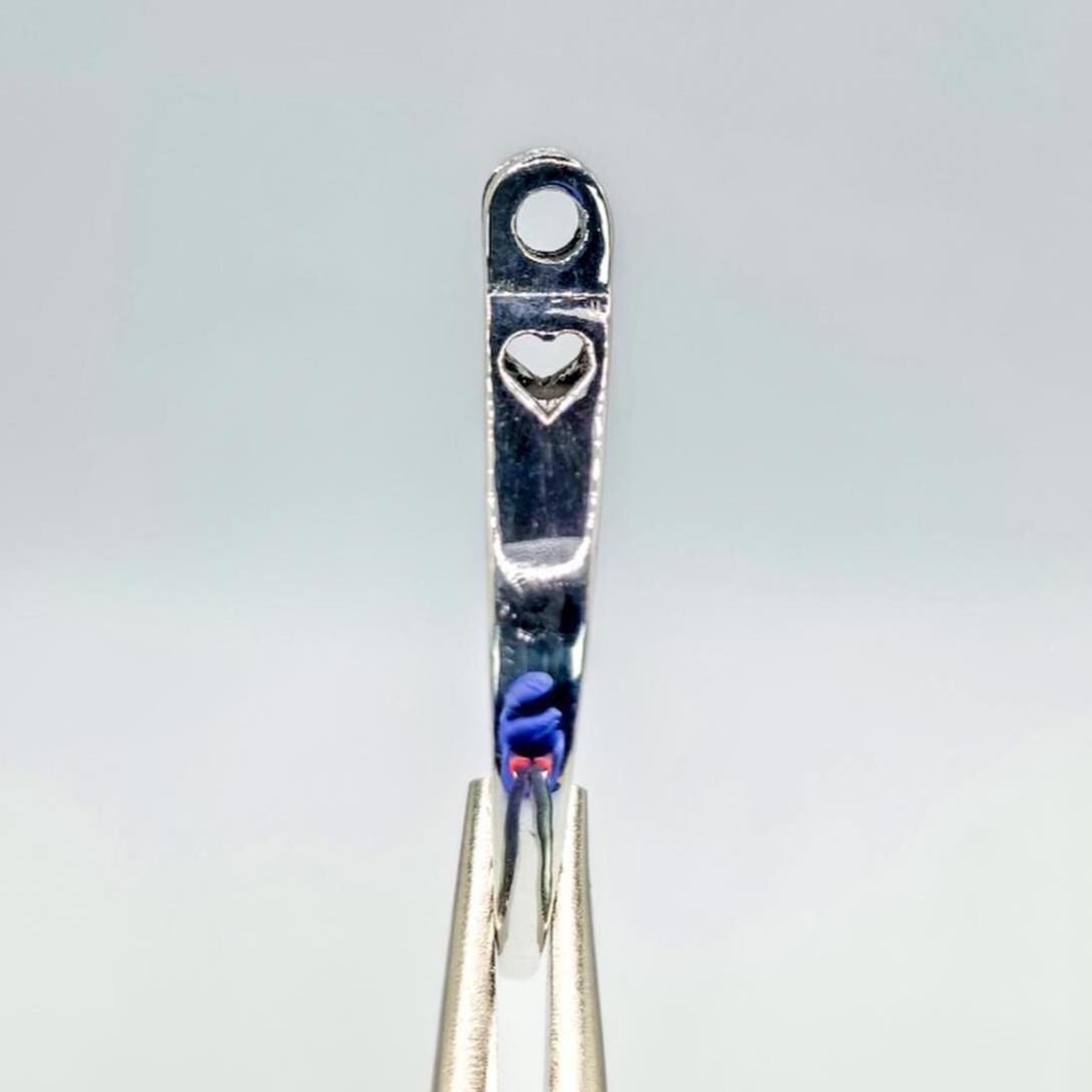 side view of the heart on the pendants side. polish reflects my hand on the side.