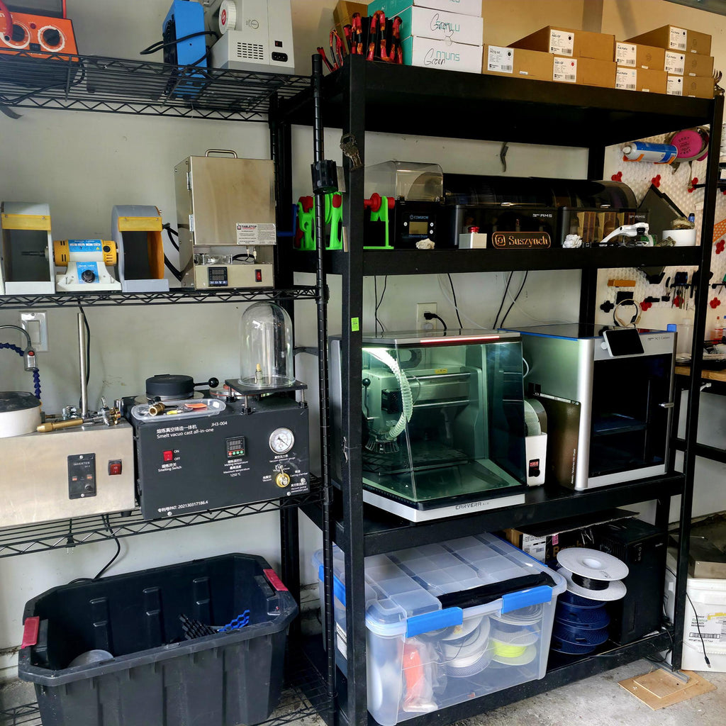 Wide shot of a maker workshop with multiple fabrication machines, including CNCs, 3D printers, and casting tools on metal shelving. The “OH SH*T BUTTON” can be seen as part of the workstation environment, symbolizing control and creative humor.