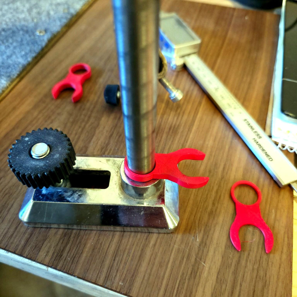 Three-quarter angle of the VEVOR faceting machine with the red spacer under the mast. The ring handle is visible for easy install and removal. Composition shows the mast, base, and index area to illustrate exact placement and how the spacer restores height for level girdle cuts.