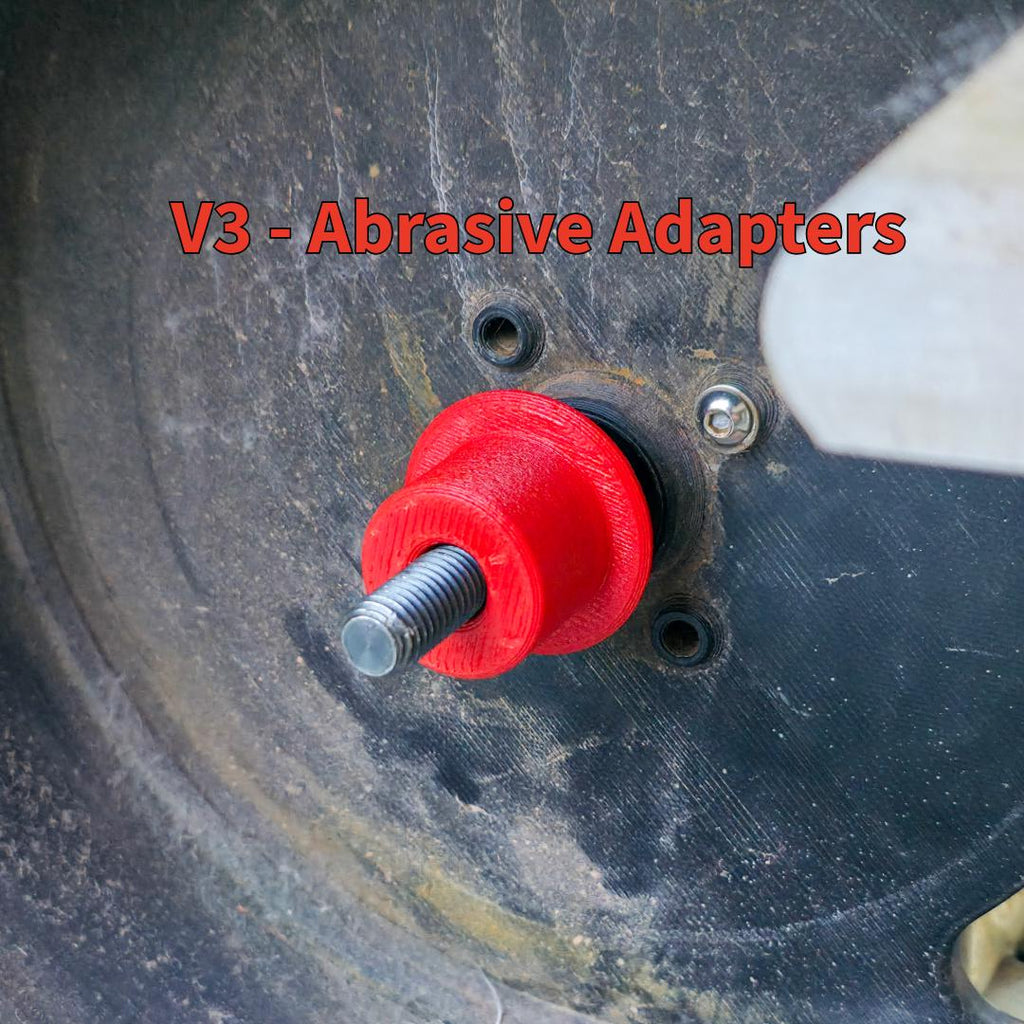 Close-up of the V3 abrasive adapter mounted on a wheel hub. The bright red polymer component threads onto the spindle shaft to hold lapidary wheels securely. The design showcases improved alignment, vibration reduction, and compatibility with the MakerSpace Edition’s modular drive system.