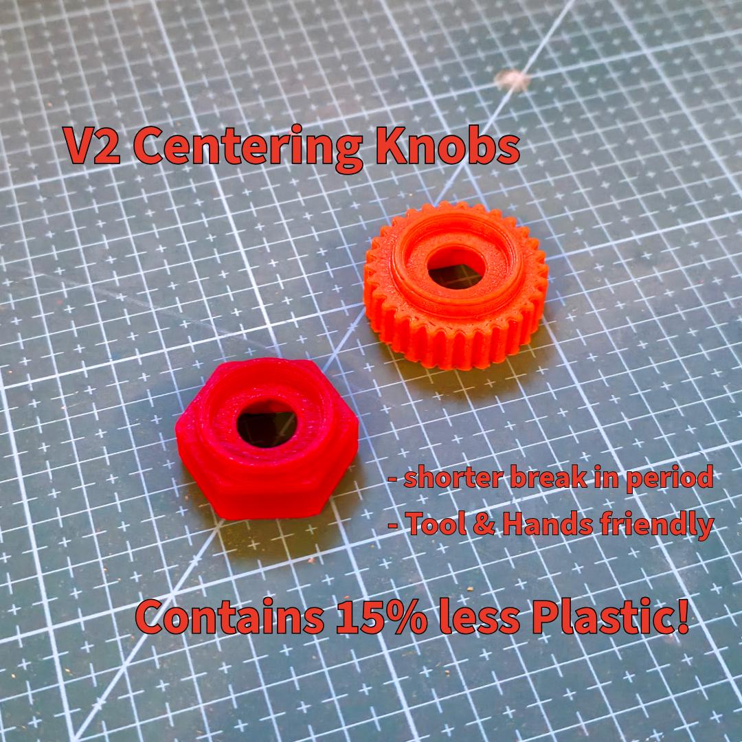 Two red centering knobs displayed on a cutting mat — one hexagonal, one with a fine-tooth grip pattern. Text notes shorter break-in period, ergonomic handling, and reduced plastic use. These updated components provide smoother centering for abrasive wheels with better tool contact and durability.
