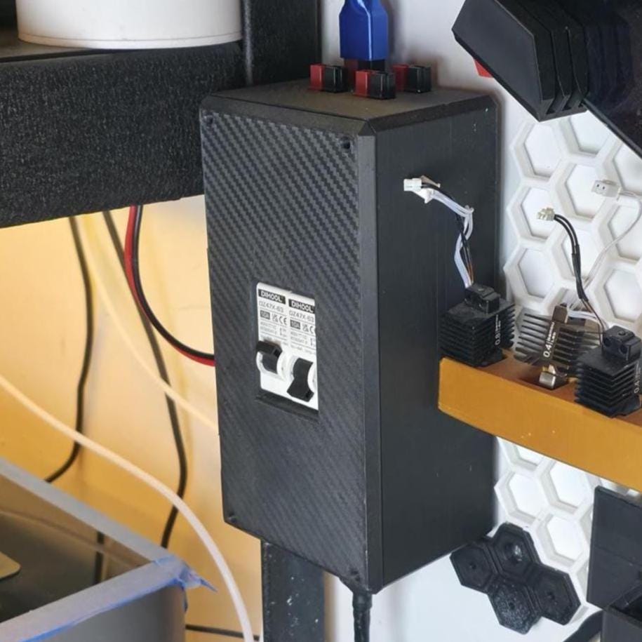 Compact DC breaker box mounted on a workbench wall with carbon fiber textured housing, featuring dual white DIHOOL 10A switches and Anderson Powerpole connectors on top. Cables route cleanly into a 12V DC power system for modular control and safety isolation.