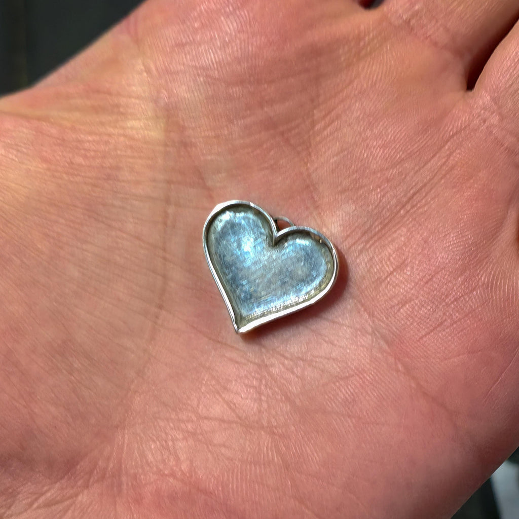 “Hand holding a small silver heart-shaped jewelry blank with a recessed center. Example of precision metal shaping and small-scale fabrication work available through the custom prototype service, including jewelry parts and bespoke metal components.”