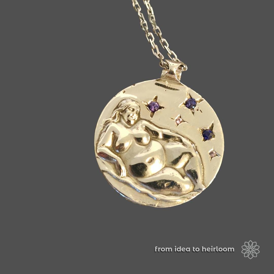 Gold medallion pendant featuring a reclining figure and star-set gemstones on a chain. Represents the final stage of a custom design process that begins with CAD and ends with polished, heirloom-quality jewelry. Highlights custom casting, engraving, and gemstone setting.