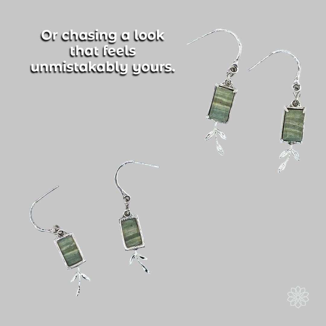 Handmade silver earrings featuring rectangular green stones with delicate leaf-shaped dangles. Floating arrangement on a soft gray background. Represents personalized style, natural motifs, and custom stone-forward designs. Ideal for clients seeking unique earrings crafted through CAD, casting, or hand fabrication.