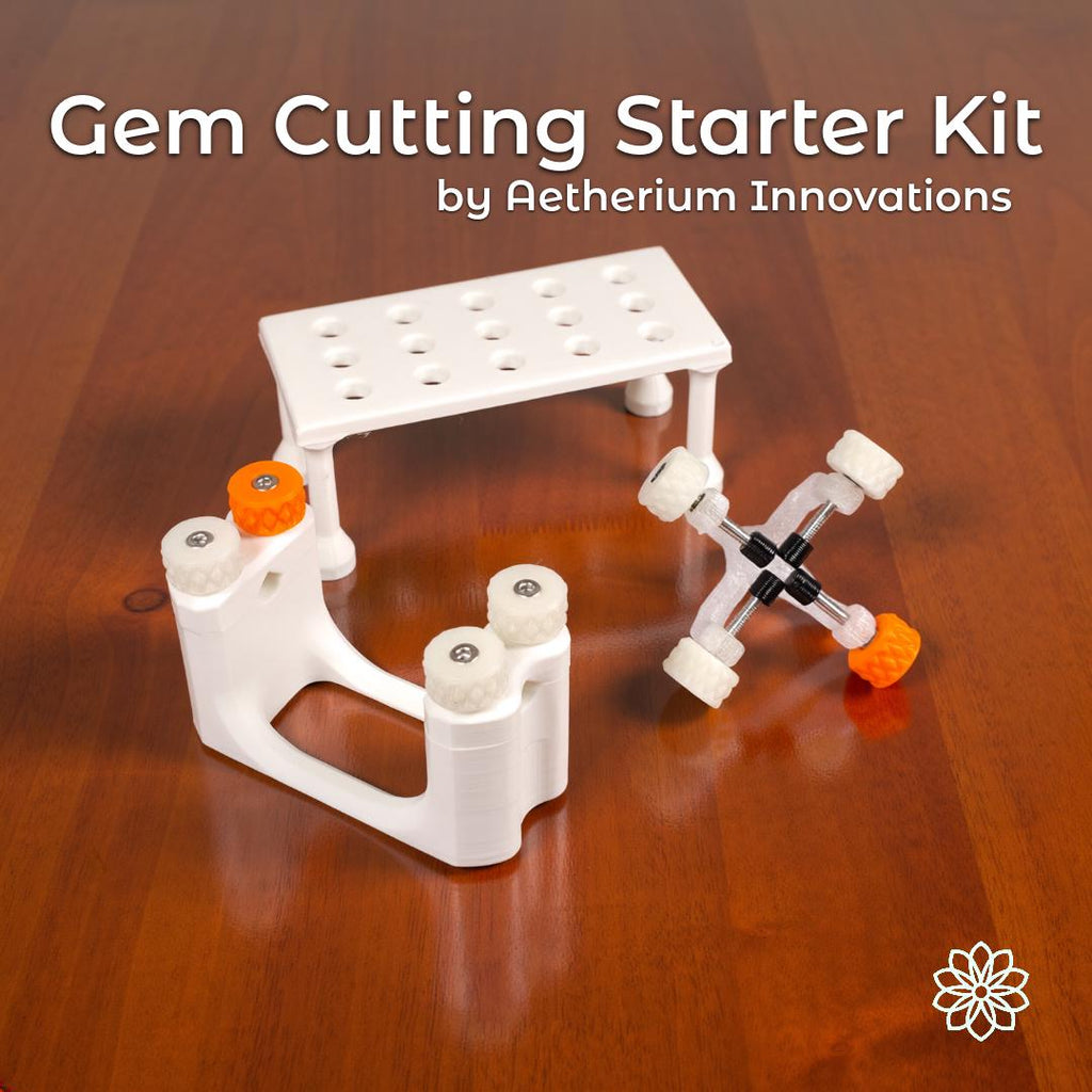 Gem Xfer Magnetic Transfer Jig, Gem Axis Alignment Tool, and dop storage rack displayed together on a wooden surface as part of the Aetherium Innovations Gem Cutting Starter Kit. White polymer construction with orange and black hardware highlights the modular design and precision components. Text overlay reads “Gem Cutting Starter Kit by Aetherium Innovations.”