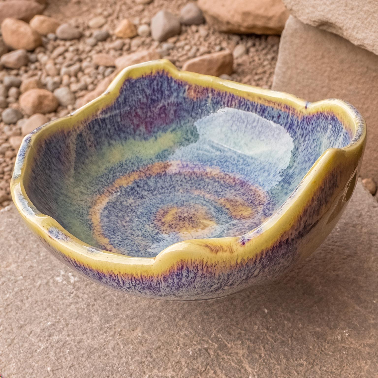Close view of the Erosion Study No. 1 bowl showing its uneven, organic rim and swirling indigo-violet glaze over a yellow base. The matte-to-gloss finish reveals layered color gradients resembling erosion patterns. Hand-thrown, kiln-fired, food-safe ceramic made in the Pacific Northwest.