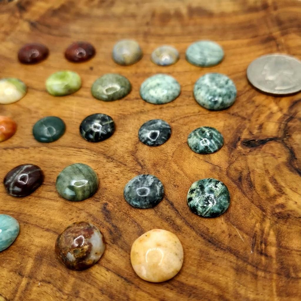 Cabochon gemstones displayed on wood with a quarter for size reference