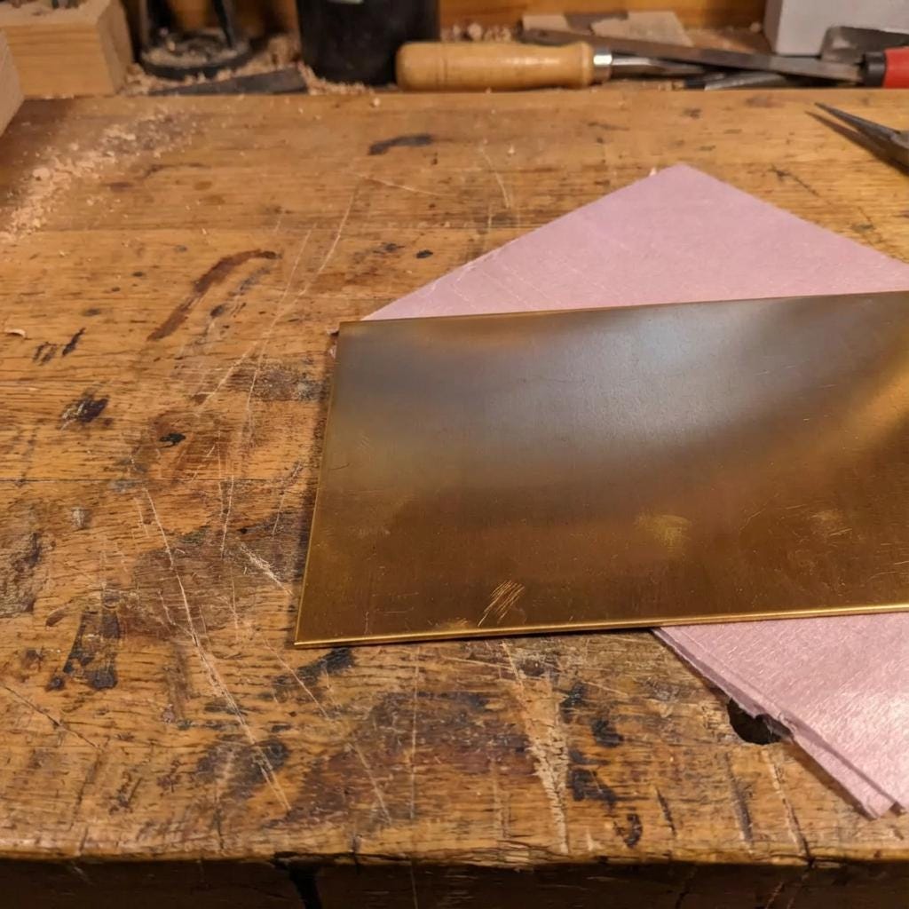 Close-up of a brass plate corner showing cleanly cut edges and a smooth, even surface finish. Fine surface marks are visible, typical of raw brass machining stock prior to CNC processing. The image highlights material quality, edge integrity, and suitability for precise CNC work.