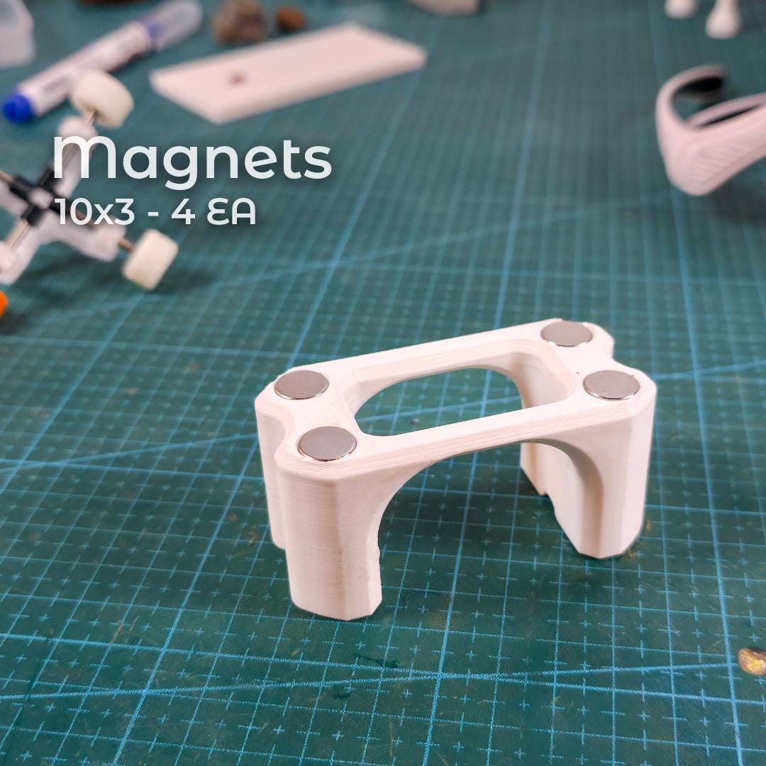 Bottom view of the Gem-Xfer epoxy cure station showing four recessed neodymium magnets installed into the 3D print. Magnets add bench stability and metal-surface adhesion. Scene highlights assembly steps for makers printing the digital jig and preparing it for gemstone transfer, epoxy curing, and dop alignment in faceting workflows.