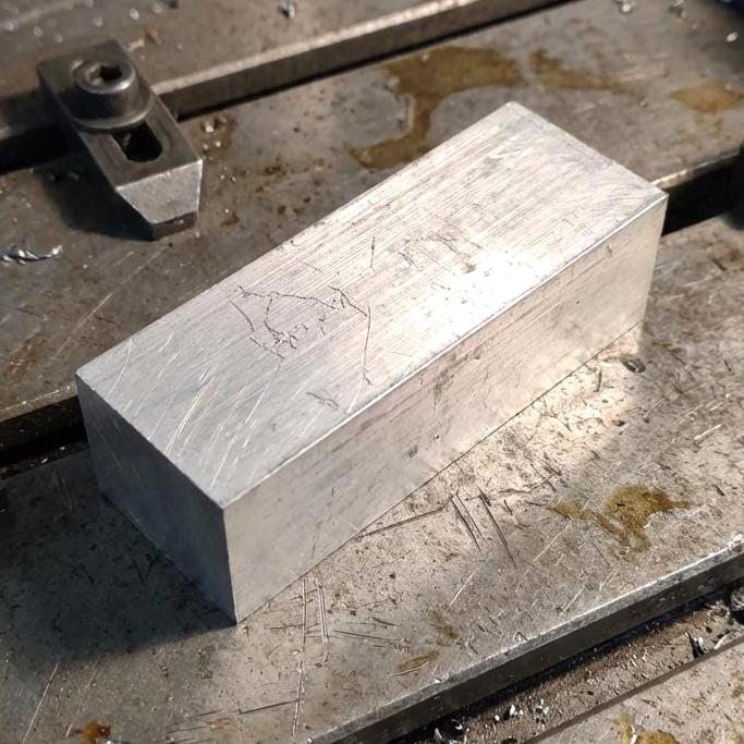 Close view of a machined 200 mm aluminum bar on a CNC work surface, showing fresh end-mill texture and squared corners. High-strength 6160-T6 stock used for milling, prototyping, custom brackets, and fabrication.