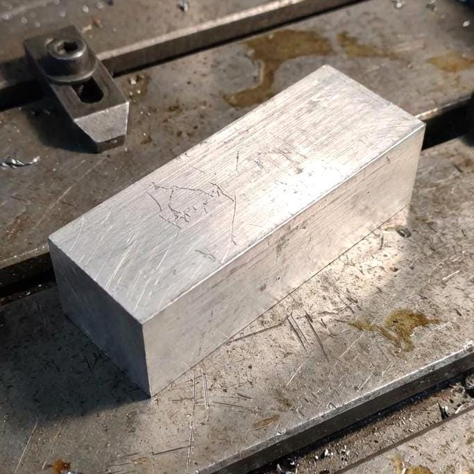 Close view of a machined 200 mm aluminum bar on a CNC work surface, showing fresh end-mill texture and squared corners. High-strength 6160-T6 stock used for milling, prototyping, custom brackets, and fabrication.