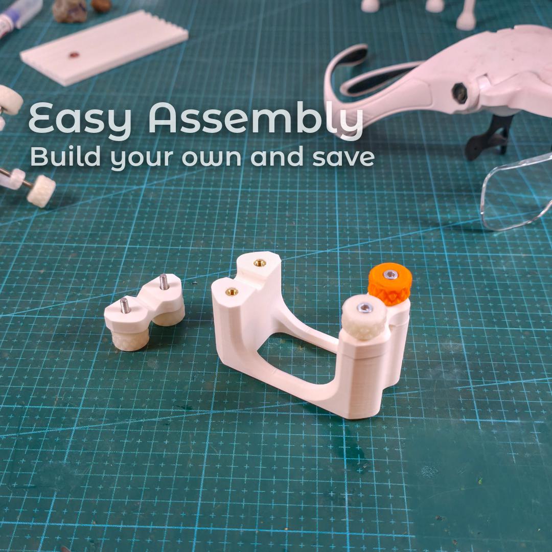 The 3D-printed Gem-Xfer jig assembled on a cutting mat beside its removable clamp module. Text overlay promotes easy assembly. Heat-set insert pockets and knurled knob posts are visible. Scene conveys DIY construction for lapidary users printing their own transfer jig for dop alignment, epoxy curing, and gemstone positioning workflows.