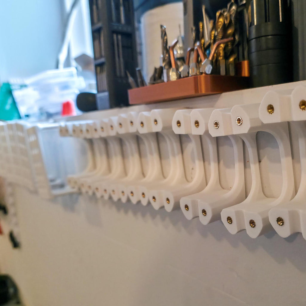 Dozens of finished Gem-Xfer epoxy cure stations lined up on a workshop shelf. Heat-set inserts are installed in each tower. The image reinforces final assembly quality and shows how the digital file can be used to produce consistent, professional-grade transfer jigs for lapidary work.