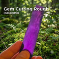 Hand holding a premium Aetherium Alexandrite crystal, showing intense purple color and translucent body. Synthetic alexandrite rough ideal for gem cutting, lapidary, and faceting. Captures rich color zoning and internal structure for high-yield stone cutters.