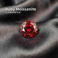 1 carat ruby red moissanite gemstone in a round Russian brilliant cut, photographed loose on dark fabric. The stone shows deep crimson color, sharp facet symmetry, and high internal fire typical of precision fancy brilliant cuts. Loose gemstone suitable for custom jewelry, engagement rings, or fine pendant designs.