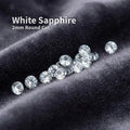 White sapphire gemstones, 2 mm round brilliant cut, loose accent stones displayed on dark velvet fabric, bright clear sparkle with uniform size, ideal for pavé settings, halo rings, and fine jewelry embellishment.