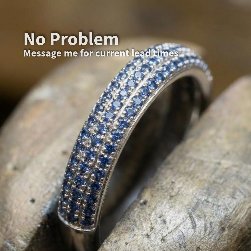 Silver ring featuring rows of small blue sapphire accent stones set in a pavé band. Example shown to demonstrate scale and application of 1 mm blue sapphires in fine jewelry and micro-setting designs.