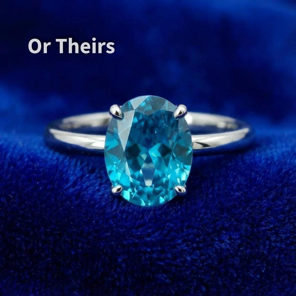 “Oval blue sapphire mounted in a four-prong silver ring setting, shown on blue velvet. The image demonstrates practical setting compatibility, prong placement, and visual balance, helping jewelers and buyers assess suitability for custom engagement or statement rings.”