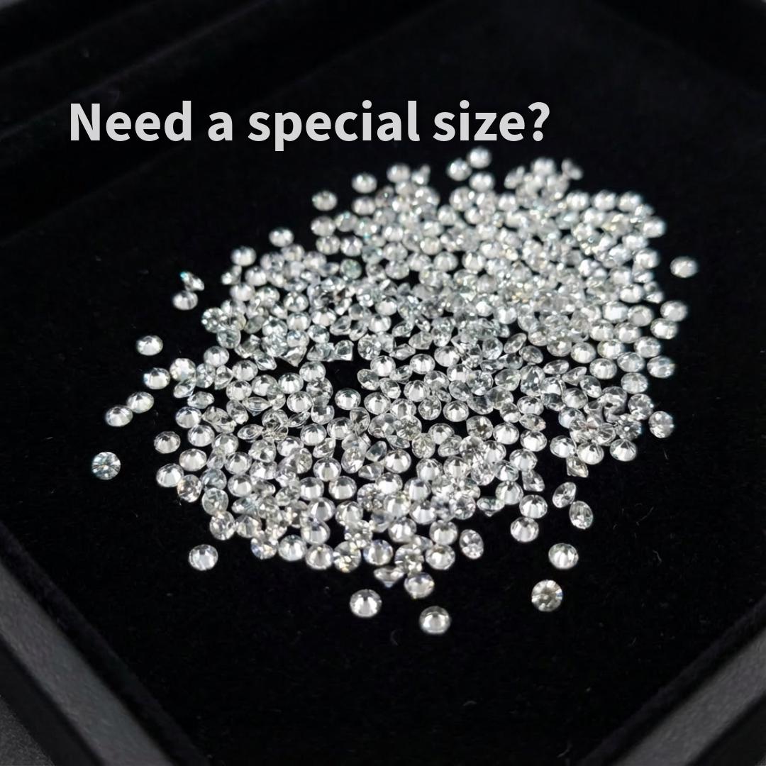 Bulk lot of small white sapphire accent stones, 2 mm round brilliant cut, loose lab-grown sapphires arranged on black tray, consistent sizing for professional jewelers and stone setters.