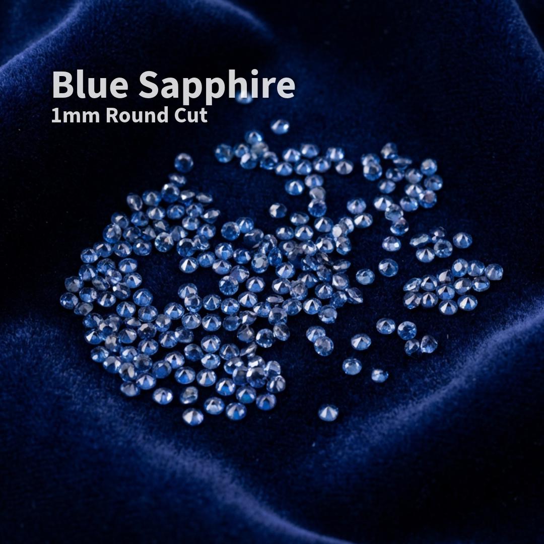 Lab-grown blue sapphire accent stones, 1 mm round brilliant cut, displayed on deep blue velvet fabric. Small precision-faceted sapphires shown as loose jewelry supply stones intended for pavé, micro-setting, and fine detail jewelry work.