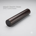 Black Delrin acetal rod shown on a clean white background, labeled CNC and lathe stock. Solid round engineering plastic rod with smooth surface finish, used for machining bushings, spacers, fixtures, and low-friction mechanical parts on CNC mills or lathes.