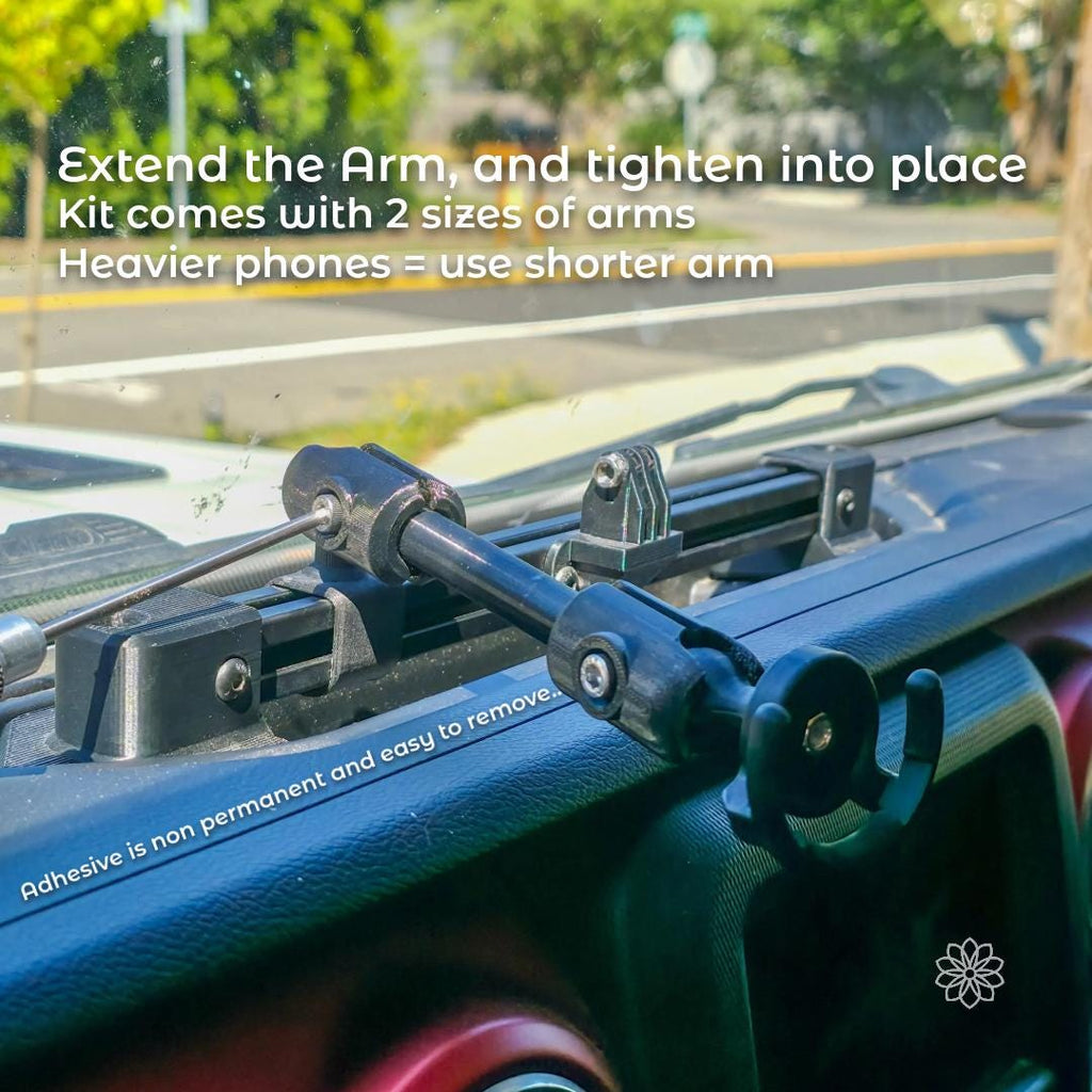 Dash accessory rail installed with an extended adjustable arm holding a phone mount, demonstrating arm length options. The image shows how the arm can be positioned and tightened, with guidance that heavier phones should use the shorter arm for increased stability.