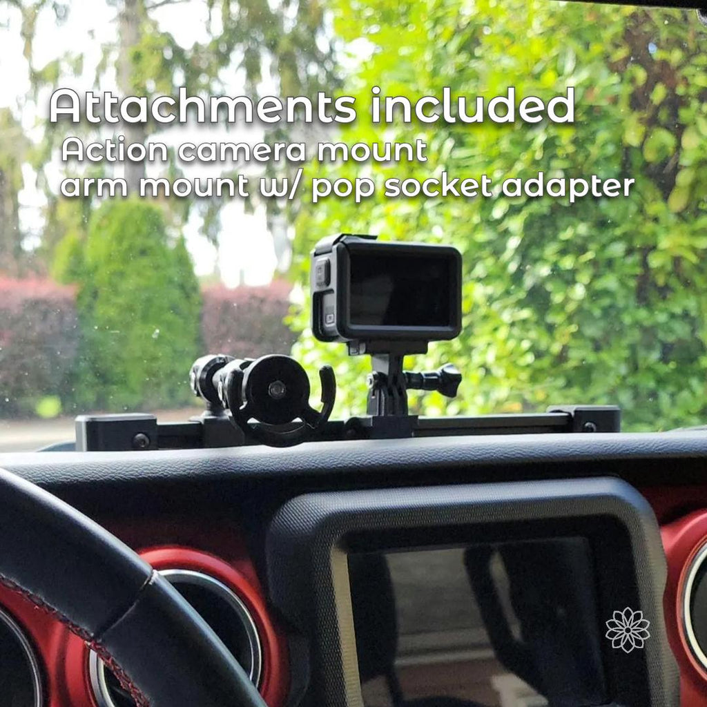 Jeep dash accessory rail shown with included attachments mounted to the aluminum extrusion, including an action camera mount and an adjustable arm with PopSocket-compatible phone holder. The system is installed across the dashboard and demonstrates multiple mounting positions along the rail for phones and cameras.