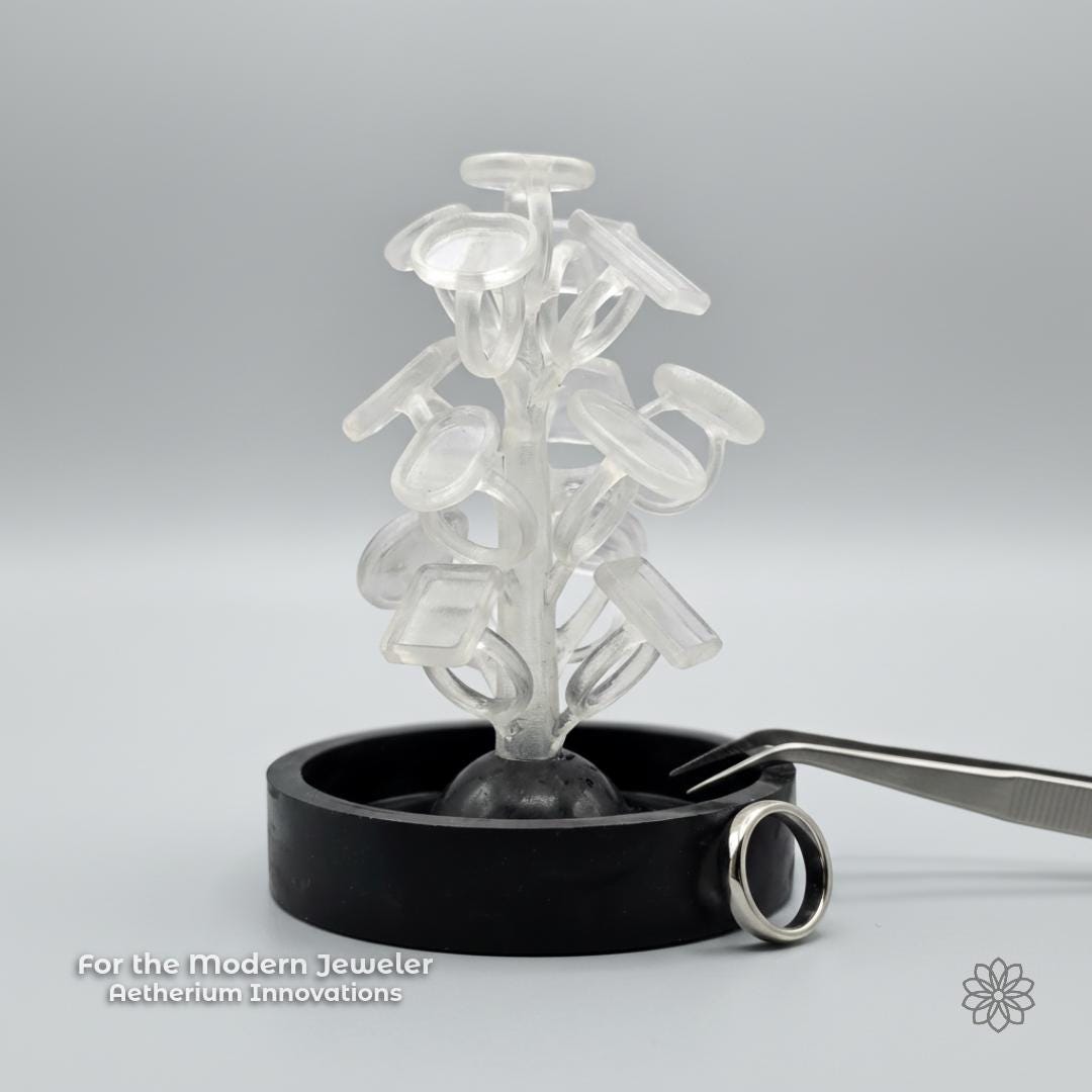 A PolyCast PVB ring blank sprue tree displayed in a clean studio setting with a finished silver ring nearby and subtle Aetherium Innovations branding. The image reinforces the connection between modern fabrication methods and traditional jewelry outcomes, emphasizing a maker-focused, process-driven approach.