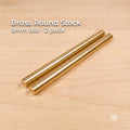 Two solid brass round stock rods shown side by side on a light wood surface, labeled “Brass Round Stock – 8 mm dia – 2 pack.” Each rod measures approximately 8 mm in diameter (0.315 in) and 100 mm in length (3.94 in). The rods have smooth cylindrical surfaces and flat cut ends, presented as CNC and lathe-ready machining stock suitable for precision turning, small parts, bushings, pins, and fine rotational work.