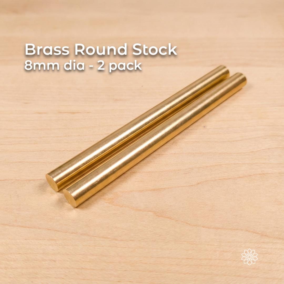 Two solid brass round stock rods shown side by side on a light wood surface, labeled “Brass Round Stock – 8 mm dia – 2 pack.” Each rod measures approximately 8 mm in diameter (0.315 in) and 100 mm in length (3.94 in). The rods have smooth cylindrical surfaces and flat cut ends, presented as CNC and lathe-ready machining stock suitable for precision turning, small parts, bushings, pins, and fine rotational work.