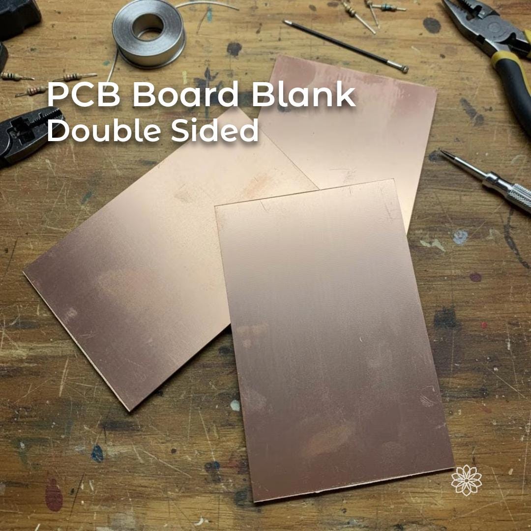 “Three double-sided copper-clad PCB boards arranged on a workbench surrounded by electronics tools, resistors, cutters, and solder. Each board has copper laminate on both faces, designed for CNC milling, DIY circuit etching, dual-layer prototypes, and custom electronics projects.”