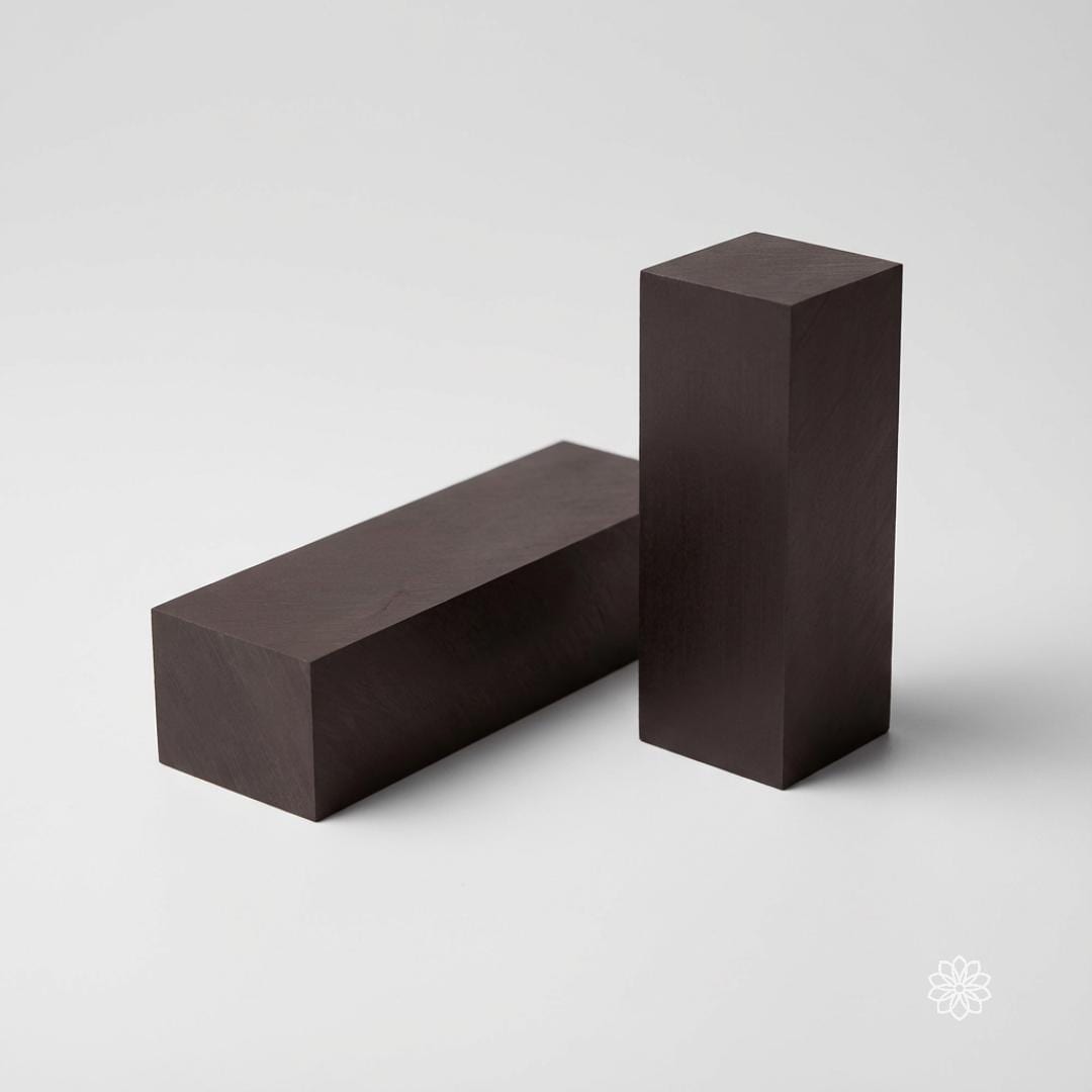 Two black Delrin square blocks displayed against a neutral background, one horizontal and one vertical, showing clean geometry and sharp edges. This image highlights the material’s uniformity and form factor for CNC square stock, acetal fixture blocks, machining practice, and prototyping applications.