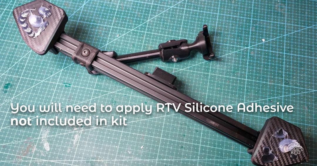 Dash accessory rail shown from below on a workbench with visible mounting bases, indicating where RTV silicone adhesive must be applied during installation. The image communicates that adhesive is required for vibration resistance and is not included in the kit.