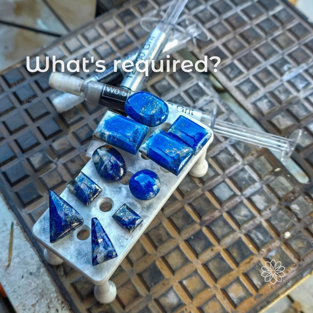 Magnetic dop stick tray loaded with finished blue gemstone cabochons, overlaid with the text “What’s required?”, placed beside syringes and lapidary tools, illustrating required materials such as epoxy and dopped stones for using the 3D-printed tray in gemstone cutting and transfer workflows.