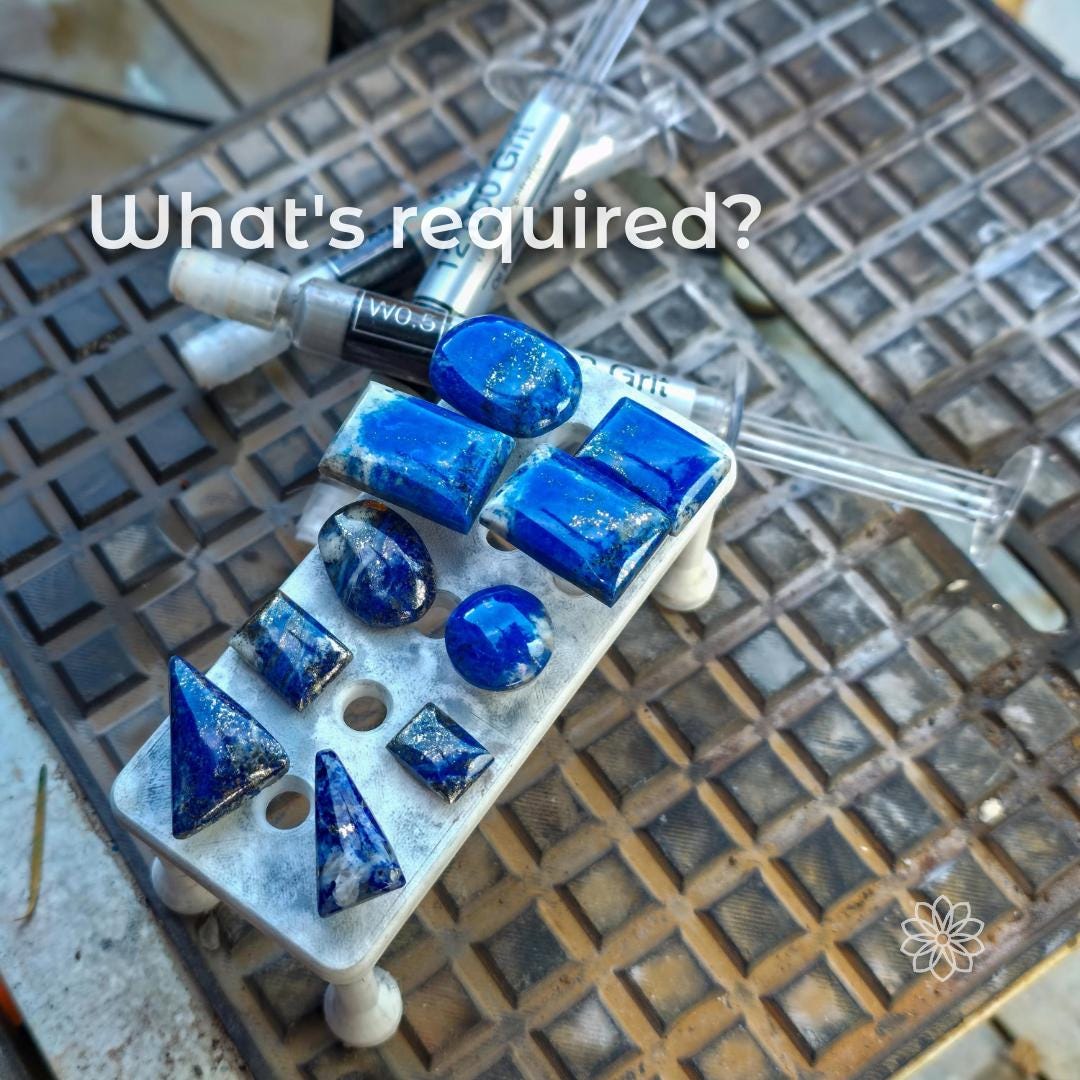 Magnetic dop stick tray loaded with finished blue gemstone cabochons, overlaid with the text “What’s required?”, placed beside syringes and lapidary tools, illustrating required materials such as epoxy and dopped stones for using the 3D-printed tray in gemstone cutting and transfer workflows.