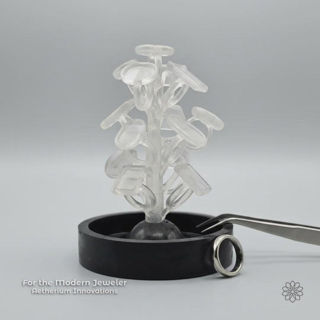 A PolyCast PVB ring blank sprue tree displayed in a clean studio setting with a finished silver ring nearby and subtle Aetherium Innovations branding. The image reinforces the connection between modern fabrication methods and traditional jewelry outcomes, emphasizing a maker-focused, process-driven approach.
