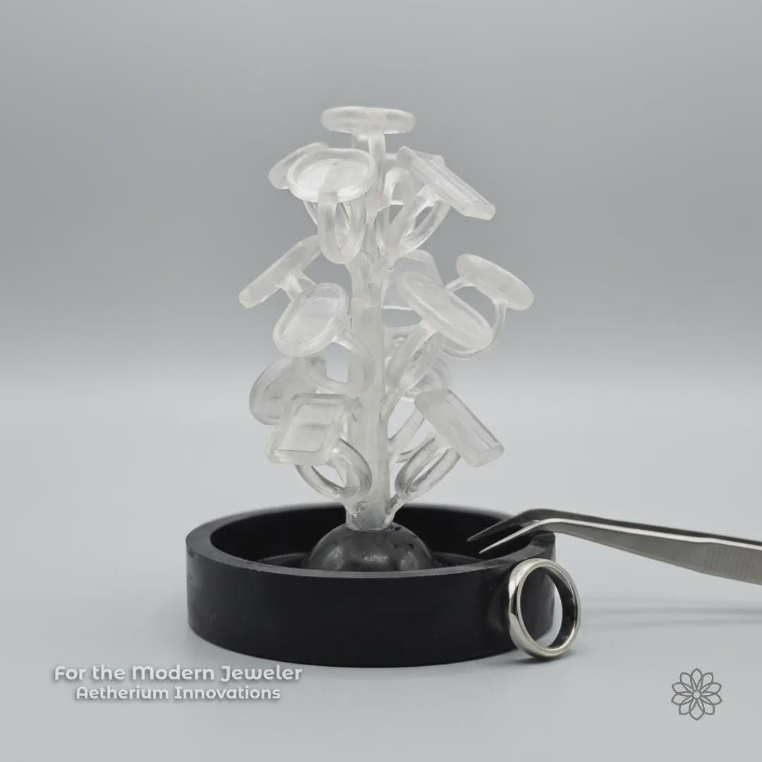 A PolyCast PVB ring blank sprue tree displayed in a clean studio setting with a finished silver ring nearby and subtle Aetherium Innovations branding. The image reinforces the connection between modern fabrication methods and traditional jewelry outcomes, emphasizing a maker-focused, process-driven approach.