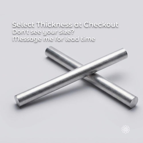 Two 7075 aluminum round stock bars crossed on a light background, showcasing consistent diameter and clean-cut ends. CNC and lathe-ready aluminum bar stock known for high strength-to-weight ratio, stiffness, and excellent machinability for structural and precision applications.