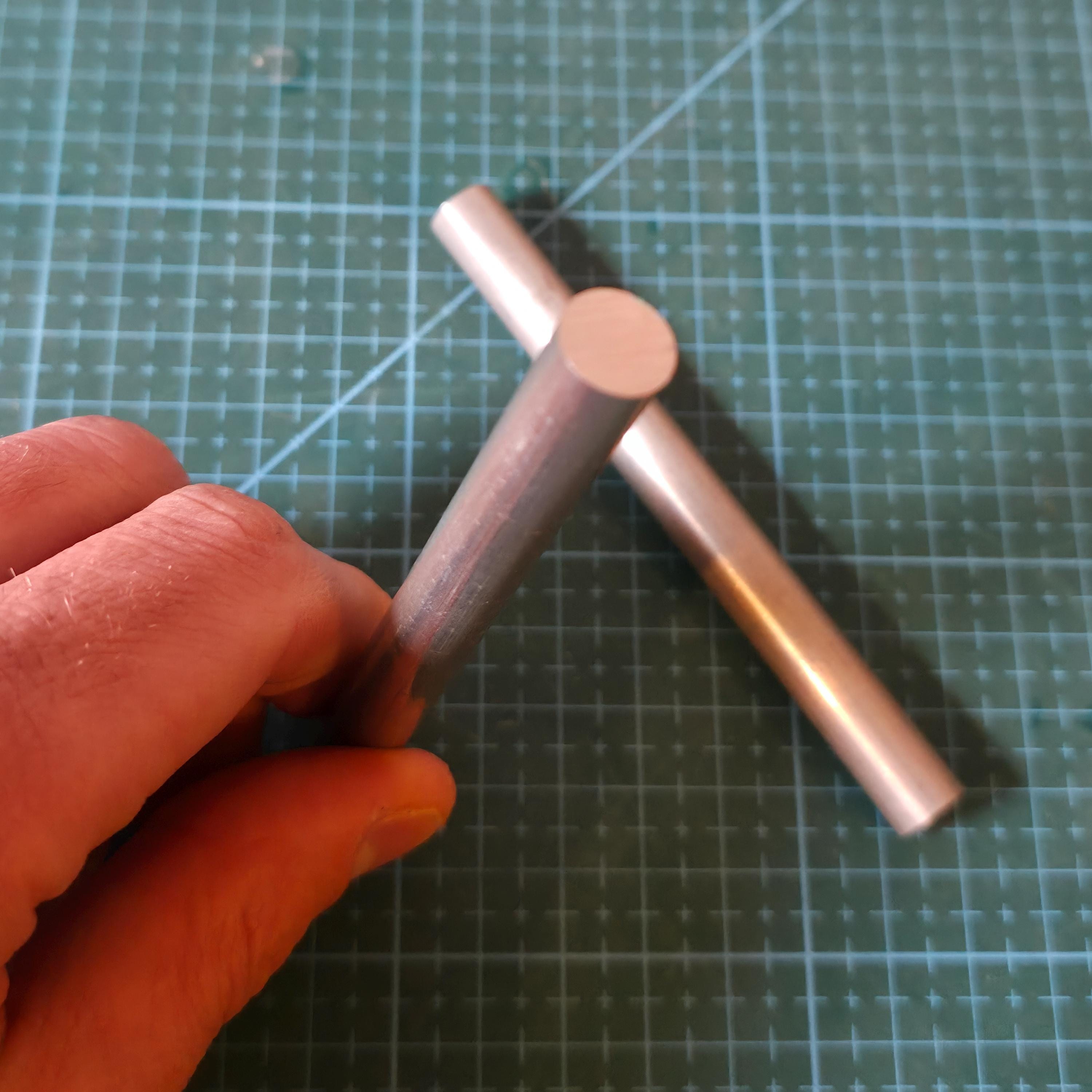 7075 aluminum round stock bars resting on a cutting mat in a workshop setting, highlighting raw machined finish and flat-cut ends. Aerospace-grade aluminum bar stock used for high-stress components, tooling, jigs, and precision CNC or manual lathe projects.