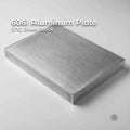 6061 Aluminum Plate CNC sheet stock, brushed silver aluminum block with clean machined faces and sharp edges on a light gray background, shown as thick plate material for milling, fixtures, jigs, and precision machining.
