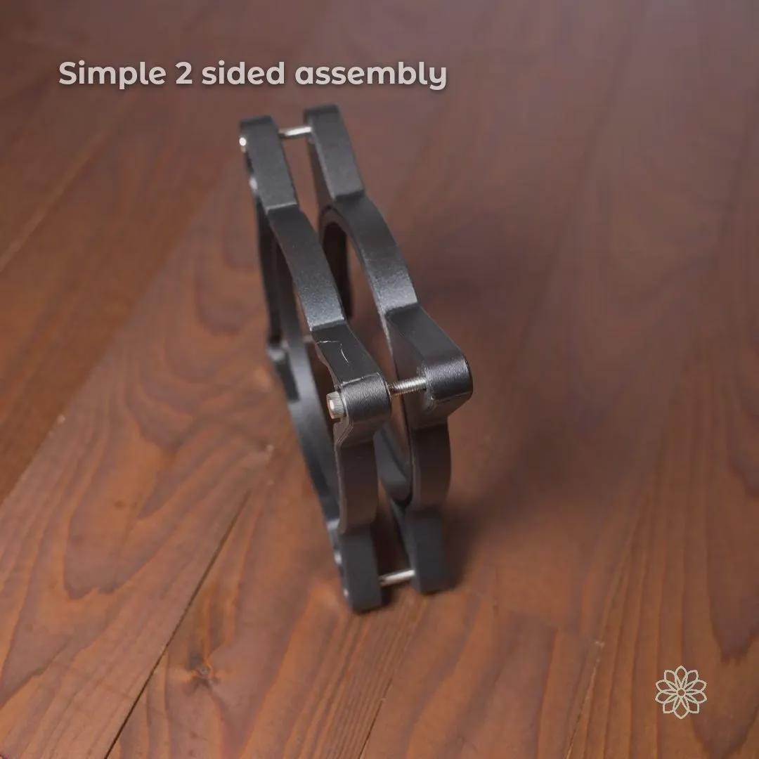 Side profile view of the Vent Link two-piece through-hull assembly bolted together, showing simple two-sided construction and alignment hardware. This image demonstrates how the adapter clamps securely through a panel or wall opening to create a stable, reversible heater duct pass-through. On-image text reads “Simple 2 sided assembly.”