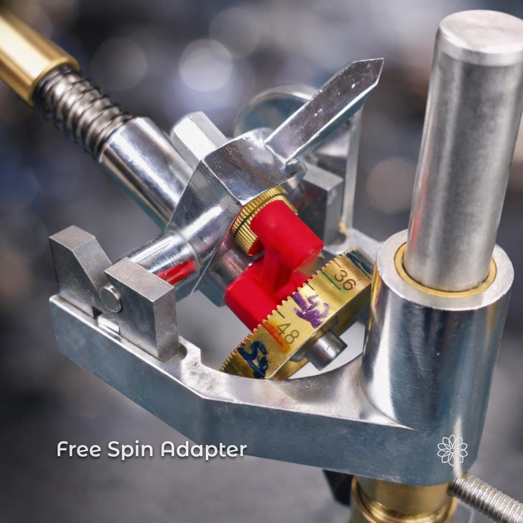 Close-up view of the faceting mast assembly featuring a brass angle dial and a red control lever installed on a metal adapter. On-image text reads “Free Spin Adapter.” The image shows the adapter mounted to the faceting machine mast, illustrating smoother rotation and improved control during gemstone cutting and setup.