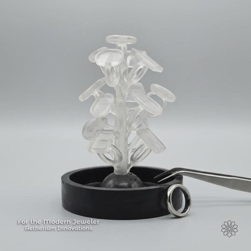 A PolyCast PVB ring blank sprue tree displayed in a clean studio setting with a finished silver ring nearby and subtle Aetherium Innovations branding. The image reinforces the connection between modern fabrication methods and traditional jewelry outcomes, emphasizing a maker-focused, process-driven approach.